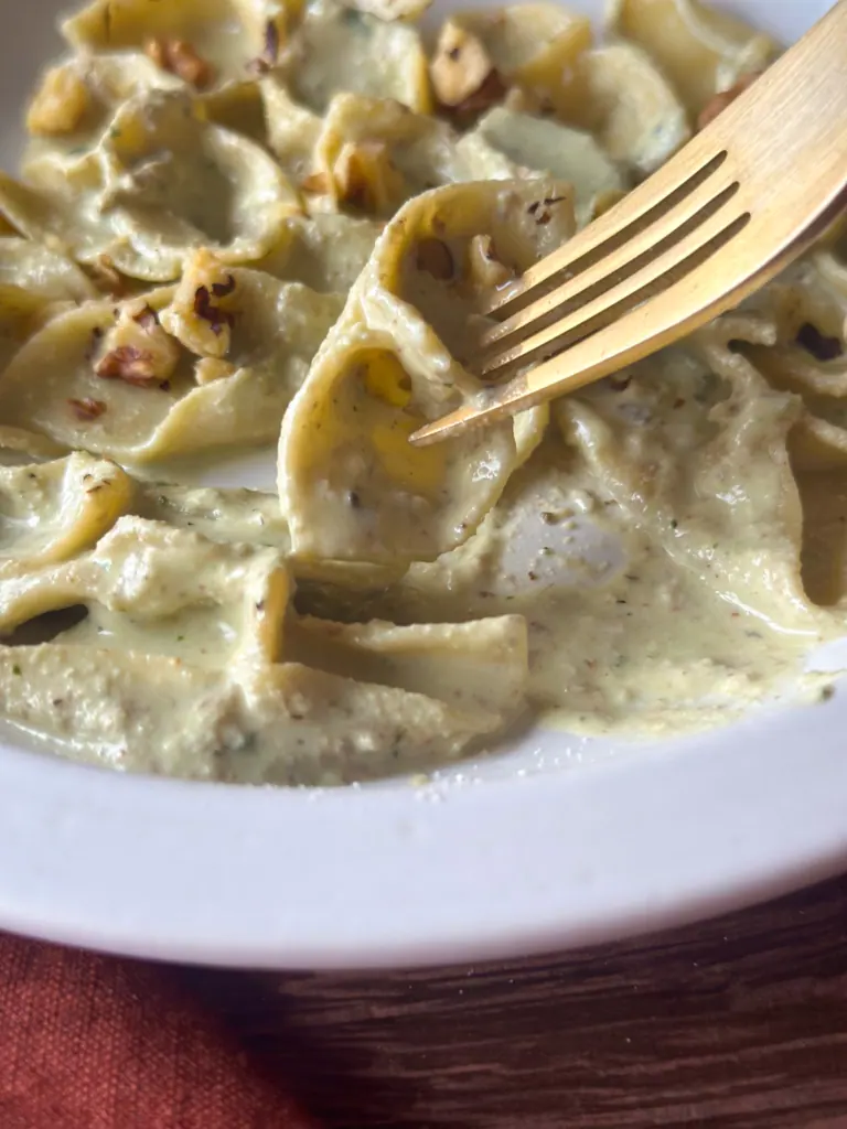close up f a bite of barchette pasta in walnut sauce
