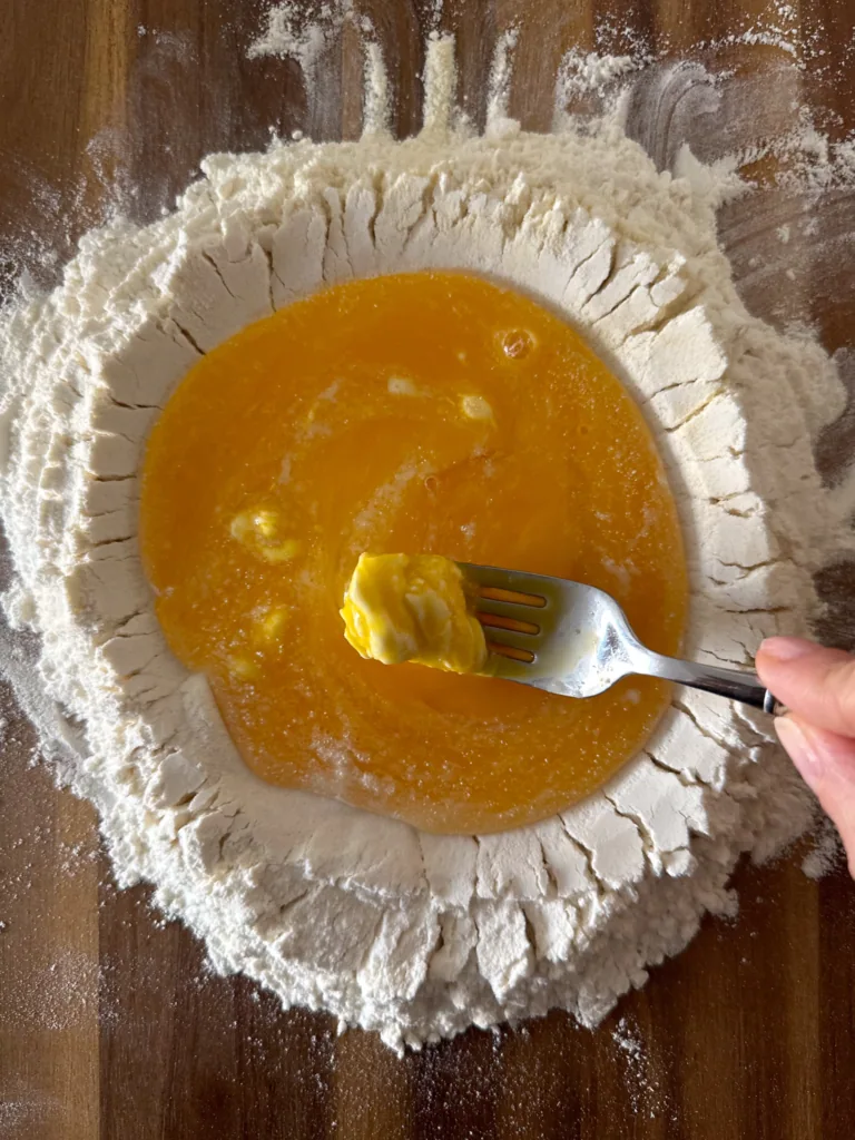 pasta dough: fork breaking the eggs