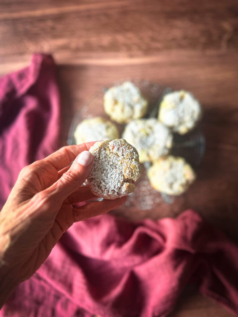 Apple Cookie in hand over a rack of cooling cookies