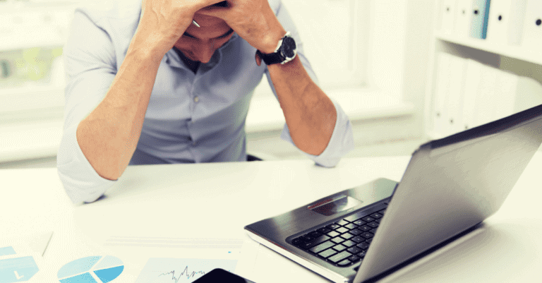 Frustrated man sits in front of laptop dealing with why his social media is failing