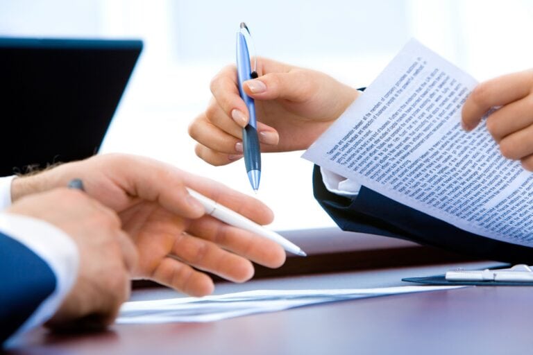 Two people signing papers