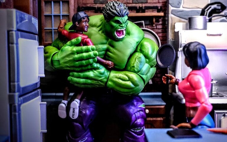Hasbro Marvel Legends Maximum Series Hulk holding Figures Toy Company’s Ethan Ultimate Wrestling Fan figure while Tasha points a frying pan in a kitchen diorama
