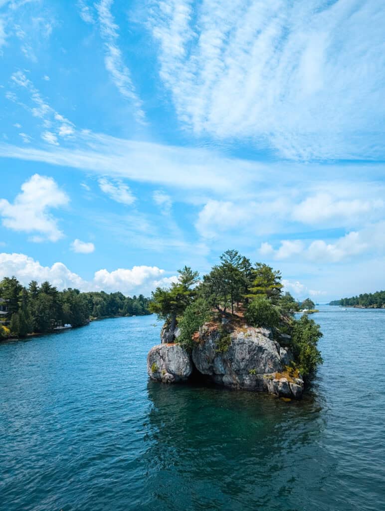 small rocky island surrounded by blue water in Thousand Islands