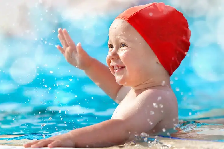 Happy toddler building water confidence during a parent and child lesson in Wimbledon