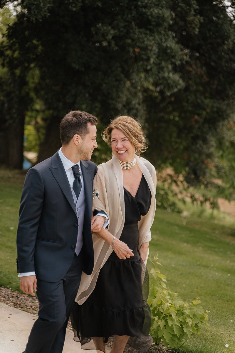 Groom walking towards the wedding ceremony location with his mom