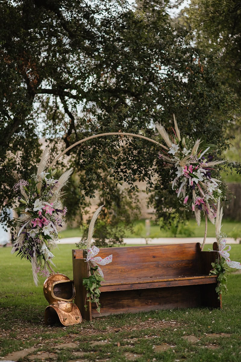 Flower arch with rustic bench as wedding decoration for garden ceremony
