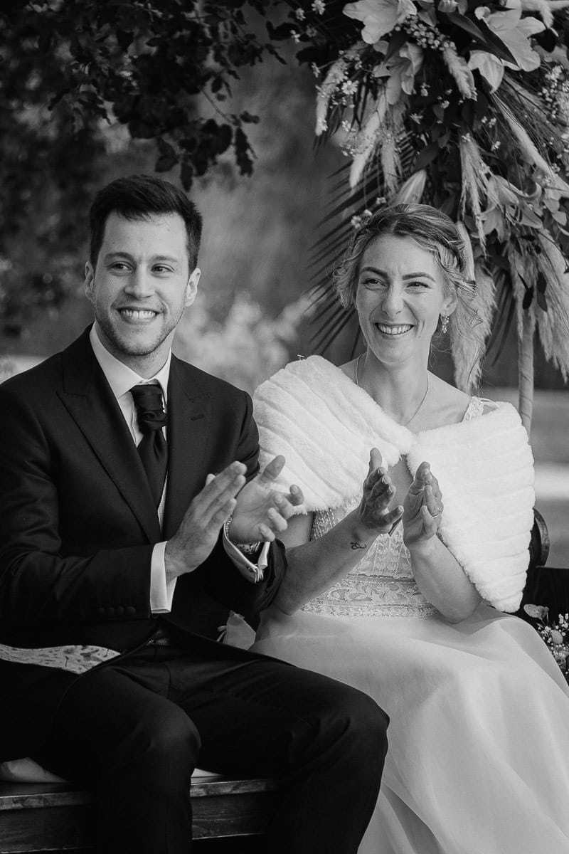 Bride and groom clapping hands after friends speech during their finca wedding ceremony at Mas Geroni