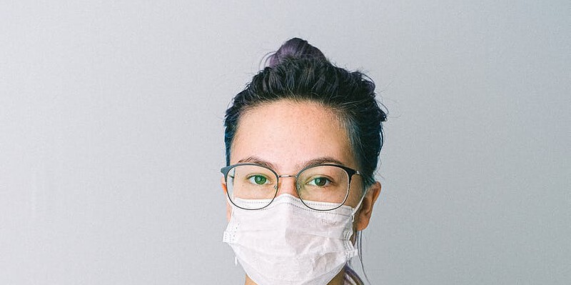 photo of person wearing protective wear while holding globe
