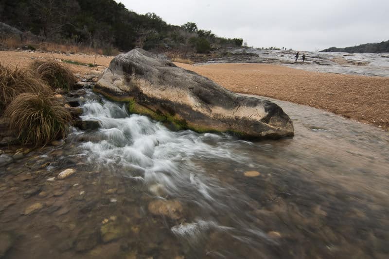 Water flowing near a large boulder at Pedernales Falls State Park