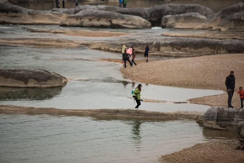 People walking around the waters edge and exploring Pedernales River