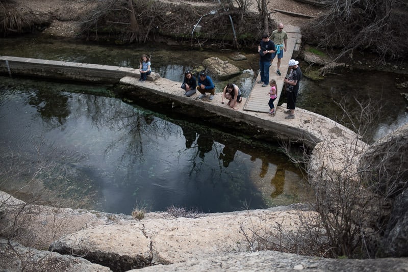 Many tourists looking into Jacob's Well from the viewing platform