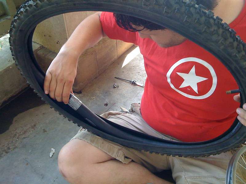 Man patches tube inside a mountain bike tire using duct tape