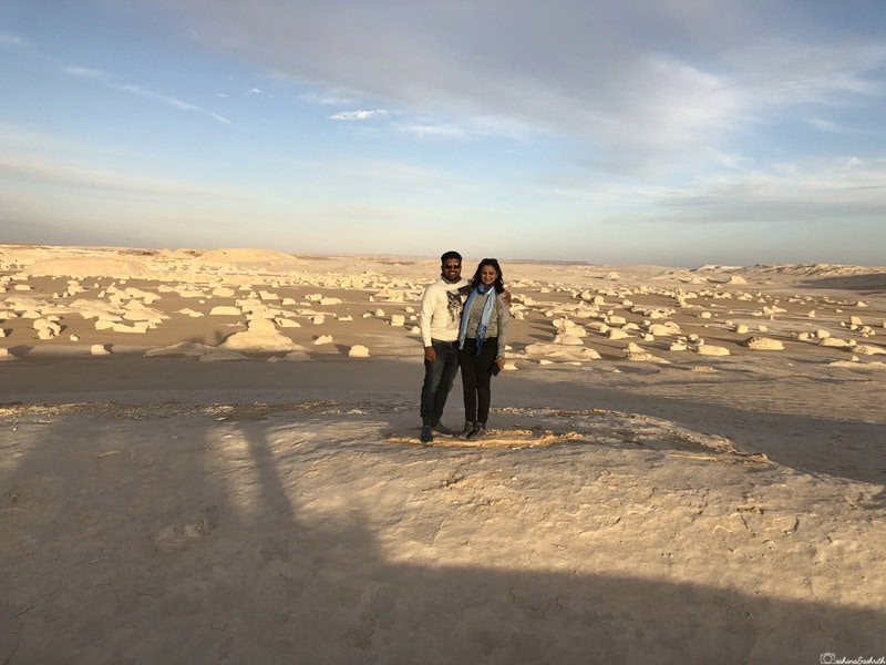 Ashrith and Sahana standing on white lime boulder with billions of lime formations in the background in Egypt