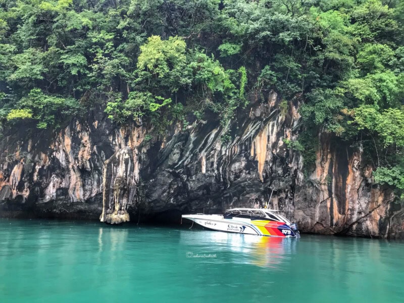 A private yacht anchored in a lagoon of emerald-colored waters at Hong Island.
