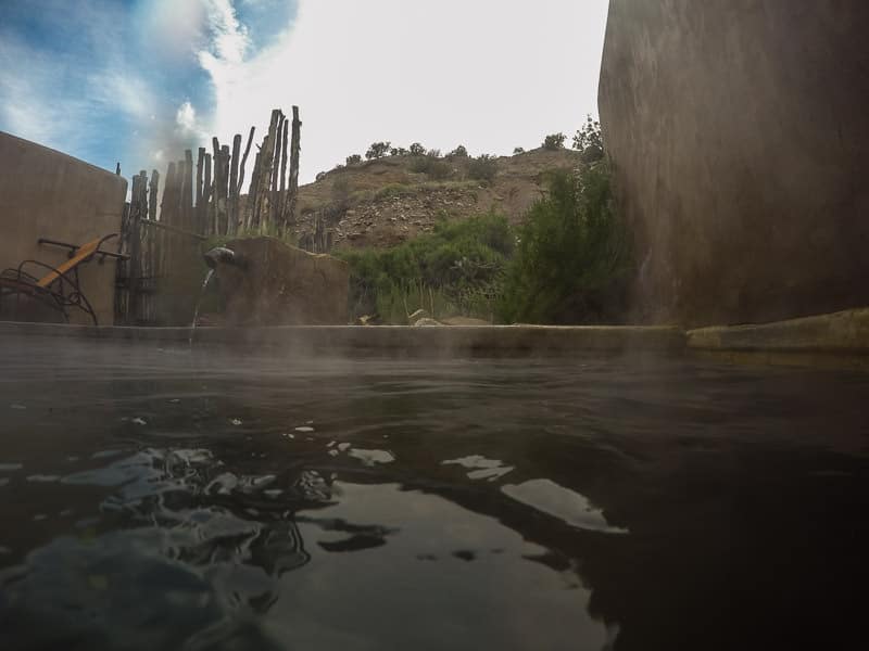 Private Pool at Ojo Caliente with athe cliffs in the bacground and steam coming off the warm water