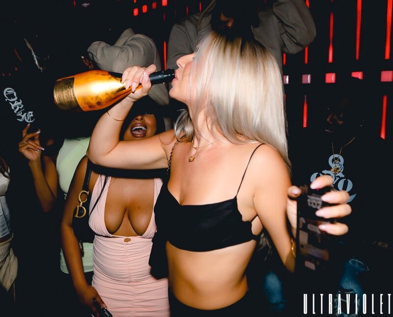 A girl drinks from an Ace of Spades bottle inside of Ultra Violet Toronto during a NYE celebration