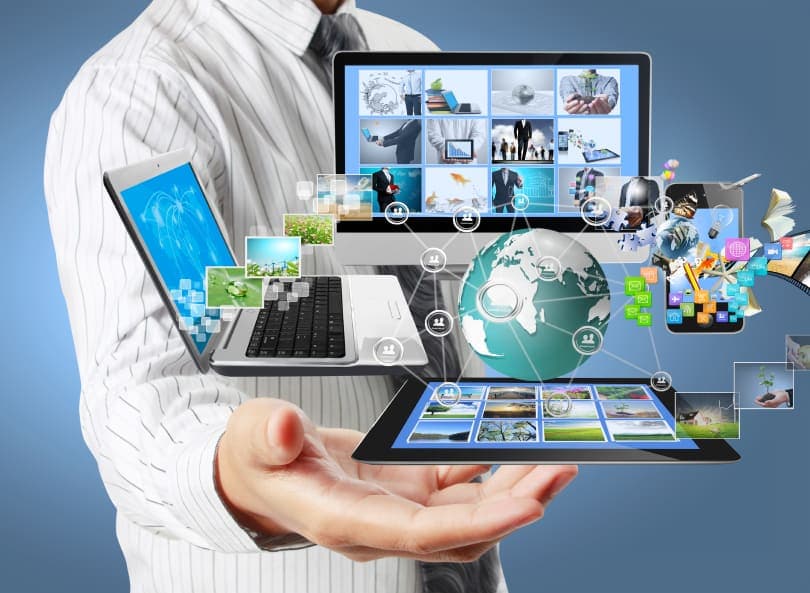 business man holding technology graphics including laptop, smartphone, tablet