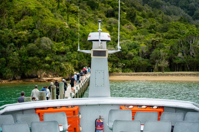 passengers walking down dock in ship cove from the picton mail boat cruise