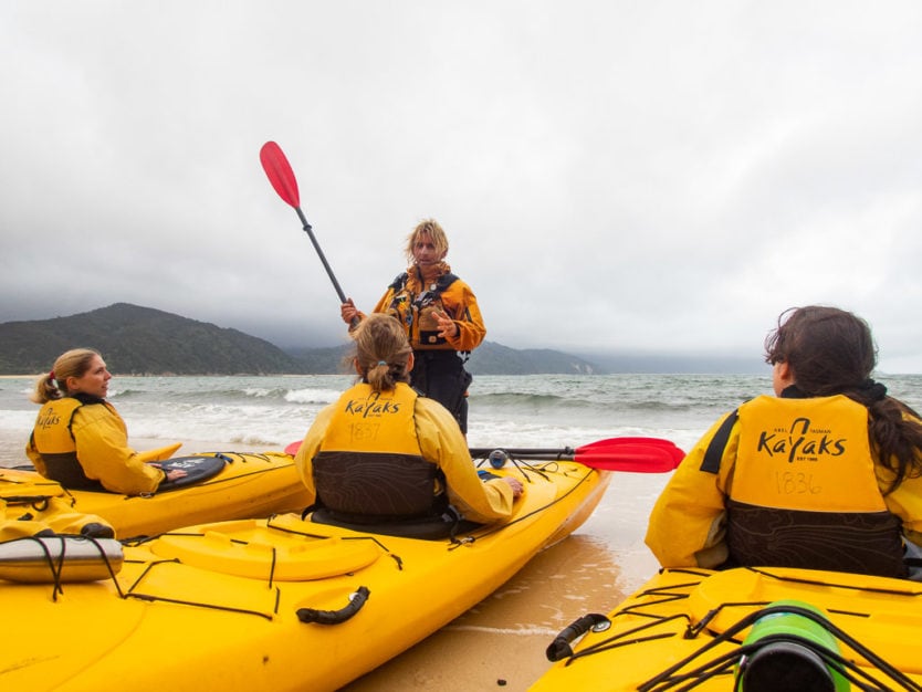 preparing to kayak in abel tasman national park with abel tasman kayaks on Awaroa Beach