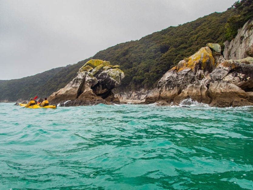 kayaking in abel tasman national park along the rocky shoreline of the tonga island marine reserve near Tonga Bay