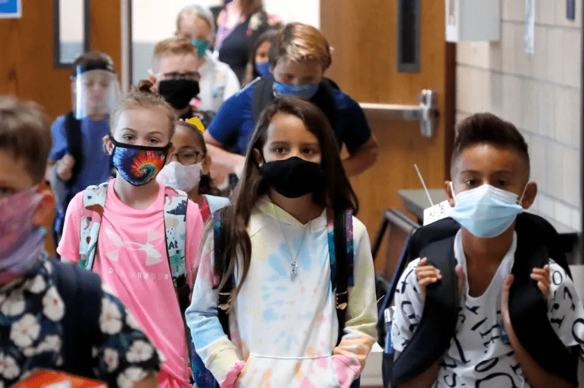 The elementary students wearing face mask in the school.