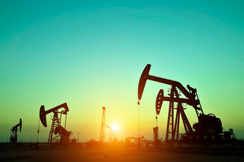 Oil drilling rig with sunrise in background