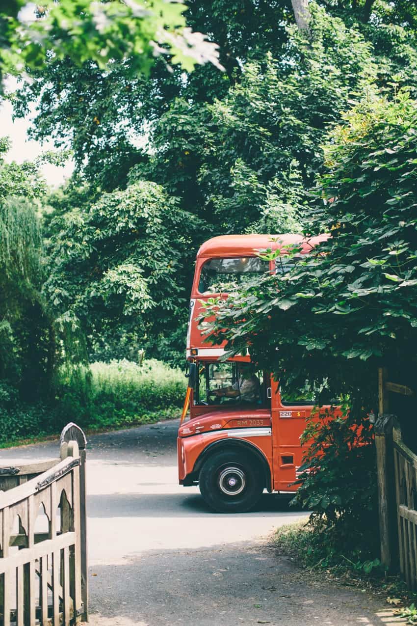 Red london bus arriving for wedding