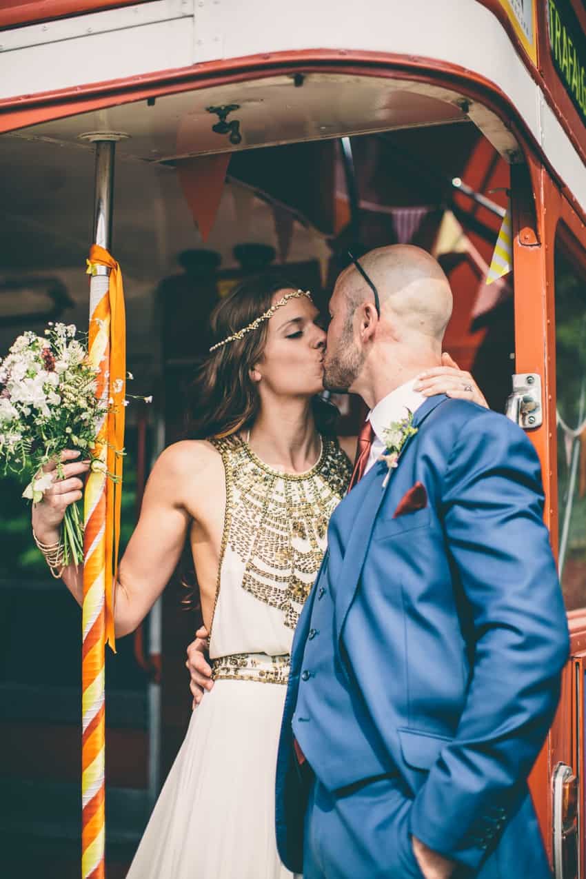 Bride and groom kiss on London red bus