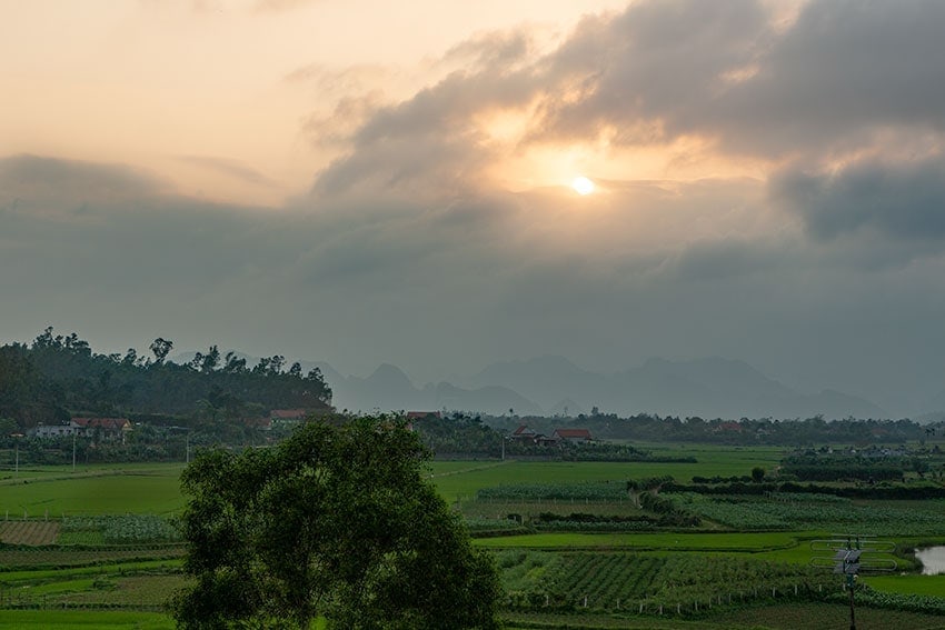 The sun sinking into the mountains at Phong Nha