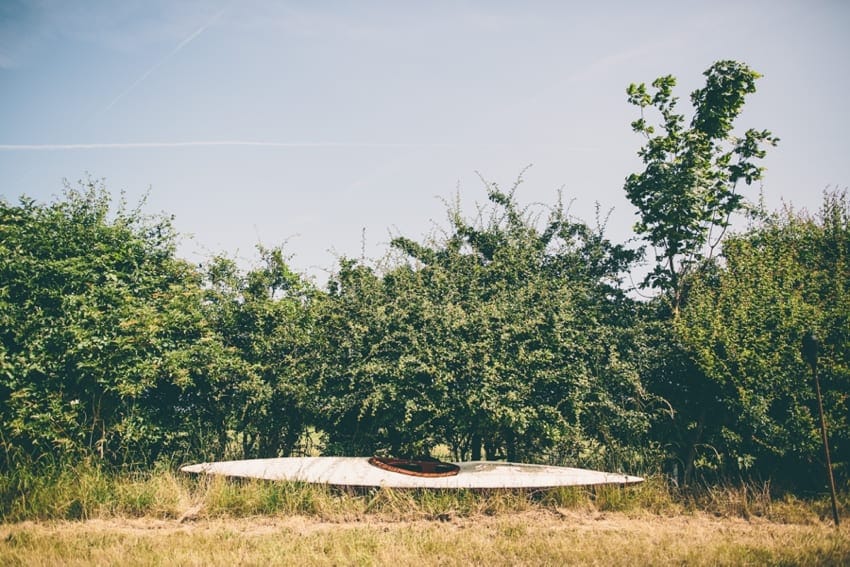 A canoe alongside a hedgerow