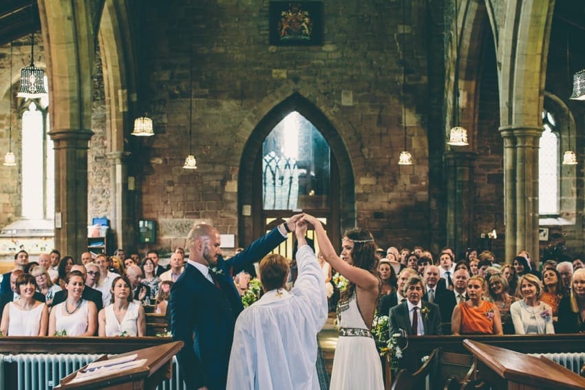 Vicar blessing bride and groom in church