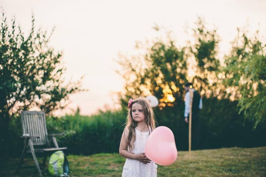 Cute flower girl with sunset and heart shaped balloon