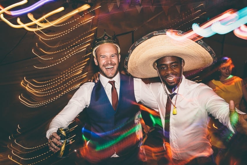 Groom and wedding guest partying in tipi