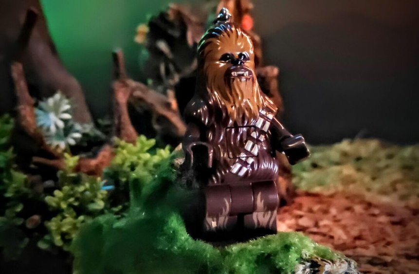 LEGO Star Wars Chewbacca keychain figure standing on mossy terrain in toy photo