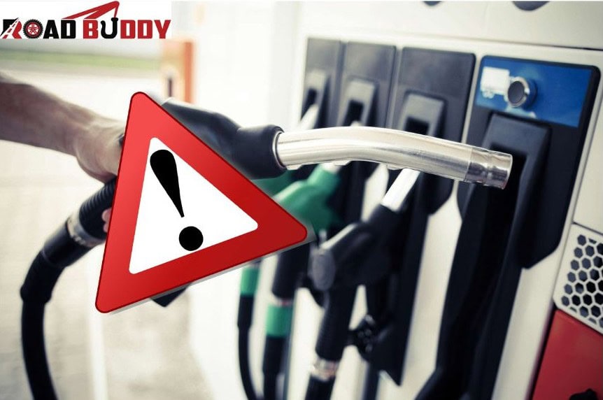 Technician draining wrong fuel from car tank at roadside emergency service