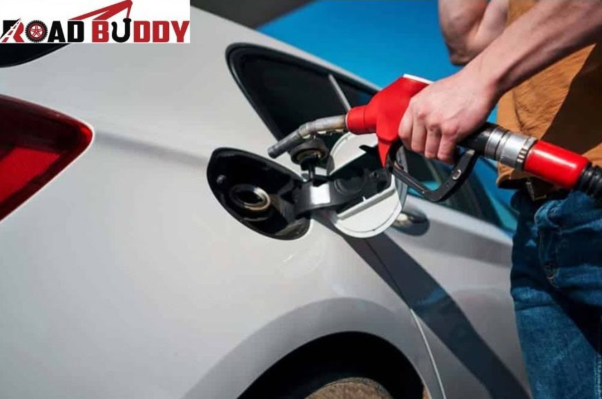 Technician refuelling stranded car with fuel container at roadside emergency service