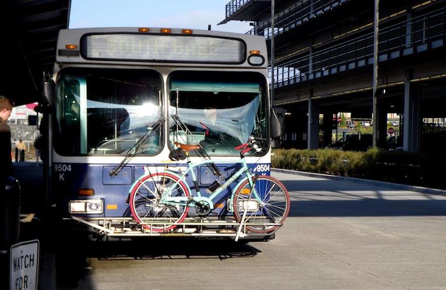 A bicycle loaded onto the bike rack at the front of a transit bus