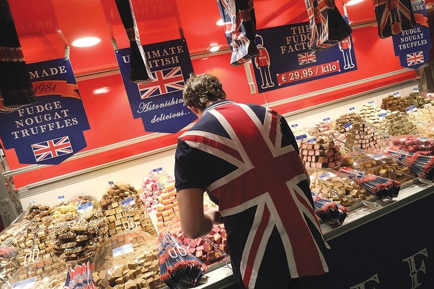 BERLIN, GERMANY - JANUARY 21: A sales assistant wearing a British flag arranges fudge at a British fudge manufacturer's stand at the International Green Week agricultural trade fair on January 21, 2019 in Berlin, Germany. The future of trade between the UK and the European Union is uncertain following the recent overwhelming rejection of British Prime Minister Theresa May's Brexit deal in the House of Commons last week. The International Green Week (Internationale Grüne Woche), among the biggest trade fairs of its kind, focuses on agriculture, horticulture and foods. (Photo by Sean Gallup/Getty Images)