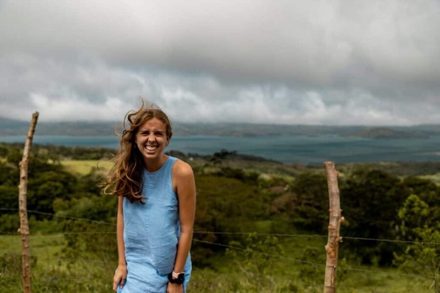 Alicia smiling at camera in front of view over lake in Costa Rica