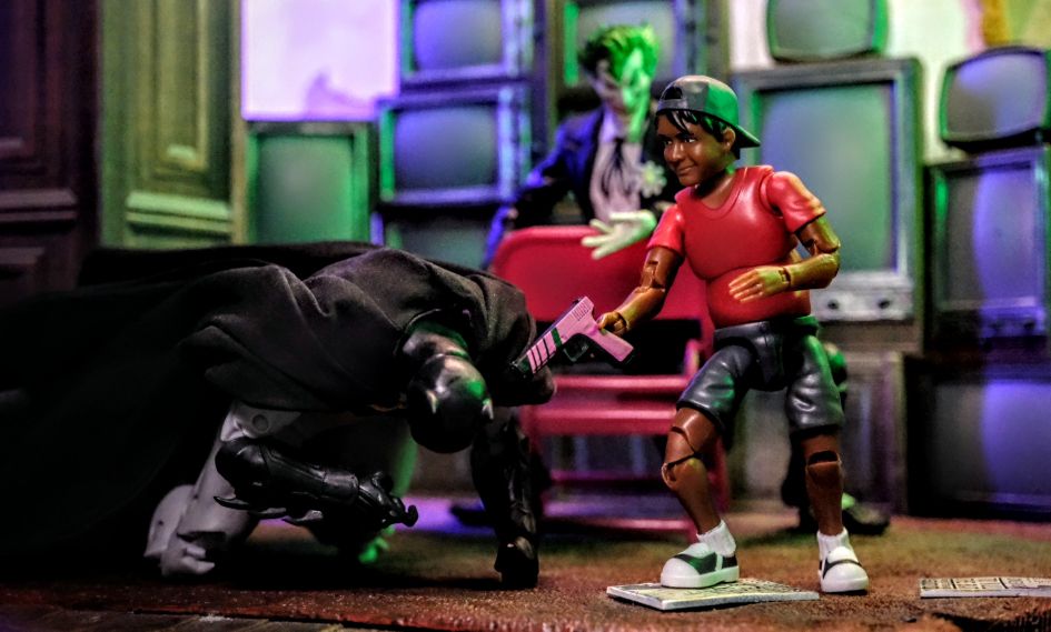 Figures Toy Company Ultimate Wrestling Fan Ethan figure holding a pink blaster over a defeated McFarlane Toys DC Multiverse Batman, with Joker watching in the background
