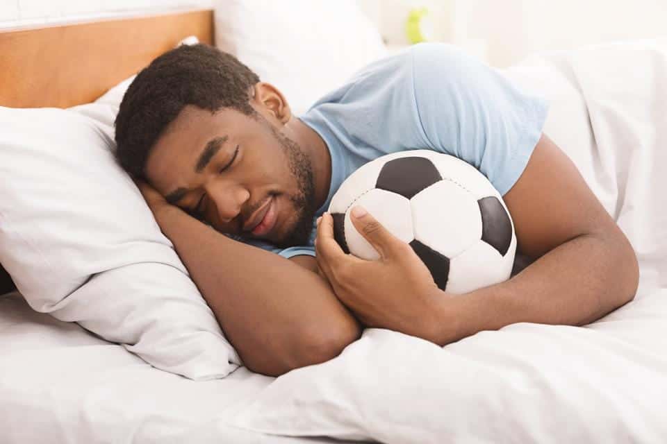 Man with soccer ball tries to fall asleep fast