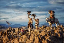 Mongolija putovanje: grupa lovaca na orlove na konjima na stenovitom grebenu