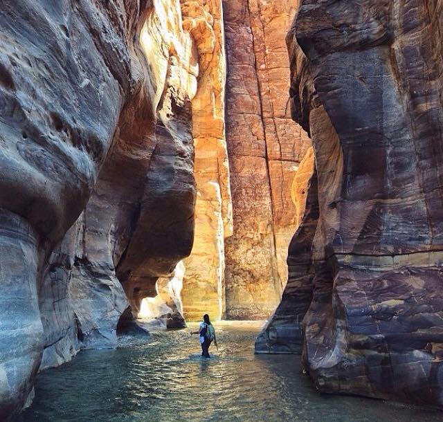 hiker in water at bottom of Mujib Gorge in Jordan