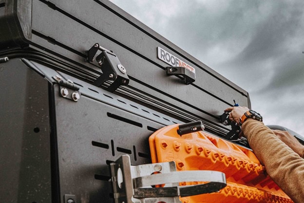 Man opening a roofnest rooftop tent