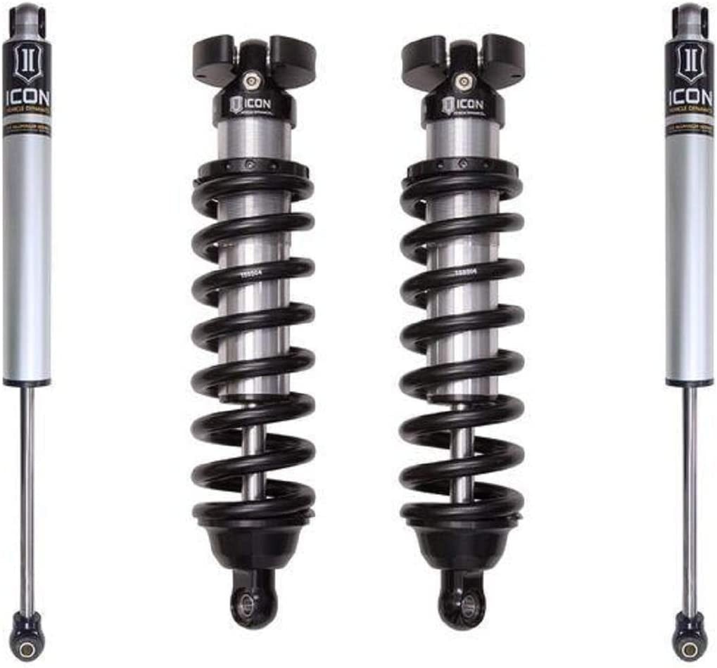 Two black and silver coilover shocks and two coil springs stand upright evenly spaced on a white background.