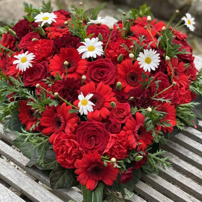 Trauergesteck Herz in rot mit Rosen und gebera und weißer kamile