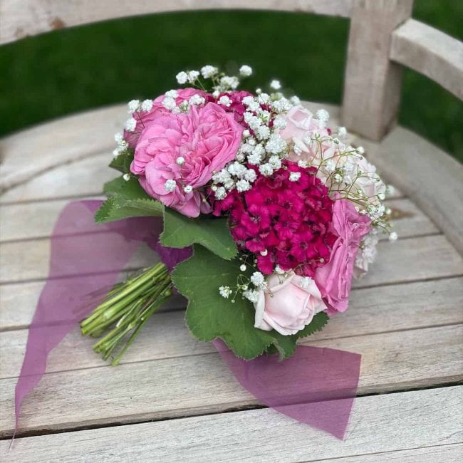 zeigt pink Brautstrauss mit Rosen
