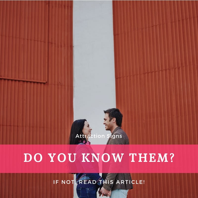 A man and woman holding hands outside a barn, both smiling, showing clear signs of mutual attraction