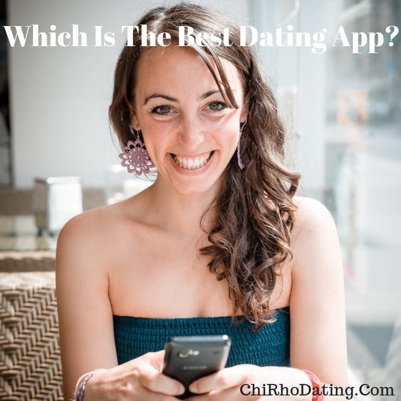 Woman in a green dress sitting at a café, smiling while holding her phone, exploring the best dating app options.