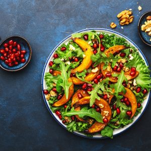 Healthy vegan eating, autumn pumpkin salad with baked honey pumpkin slices